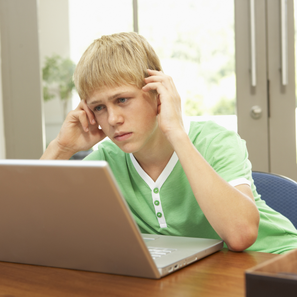 Teen looking worried about GCSE exams while sitting at a desk