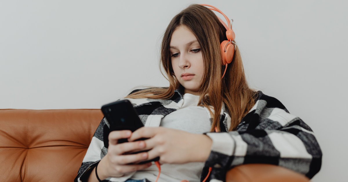 Teen avoiding GCSE revision by scrolling on phone instead of studying